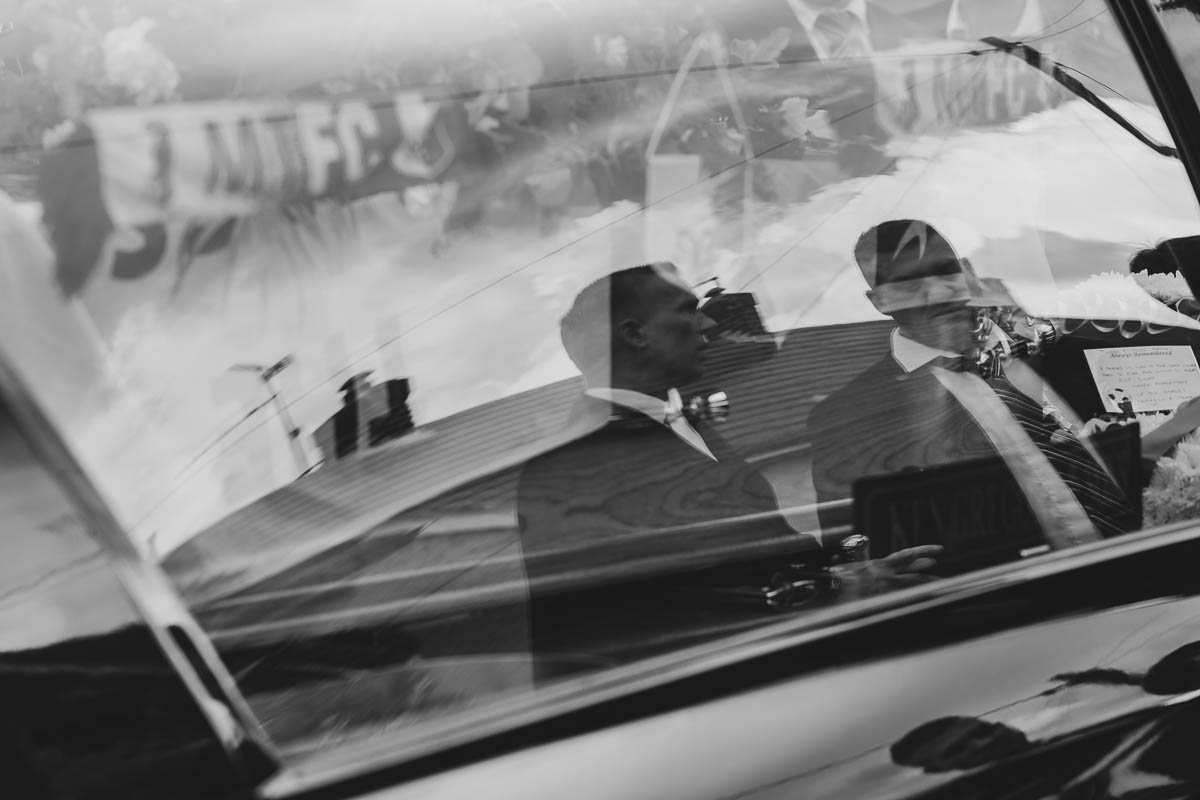 Reflection of two men in Hearse window